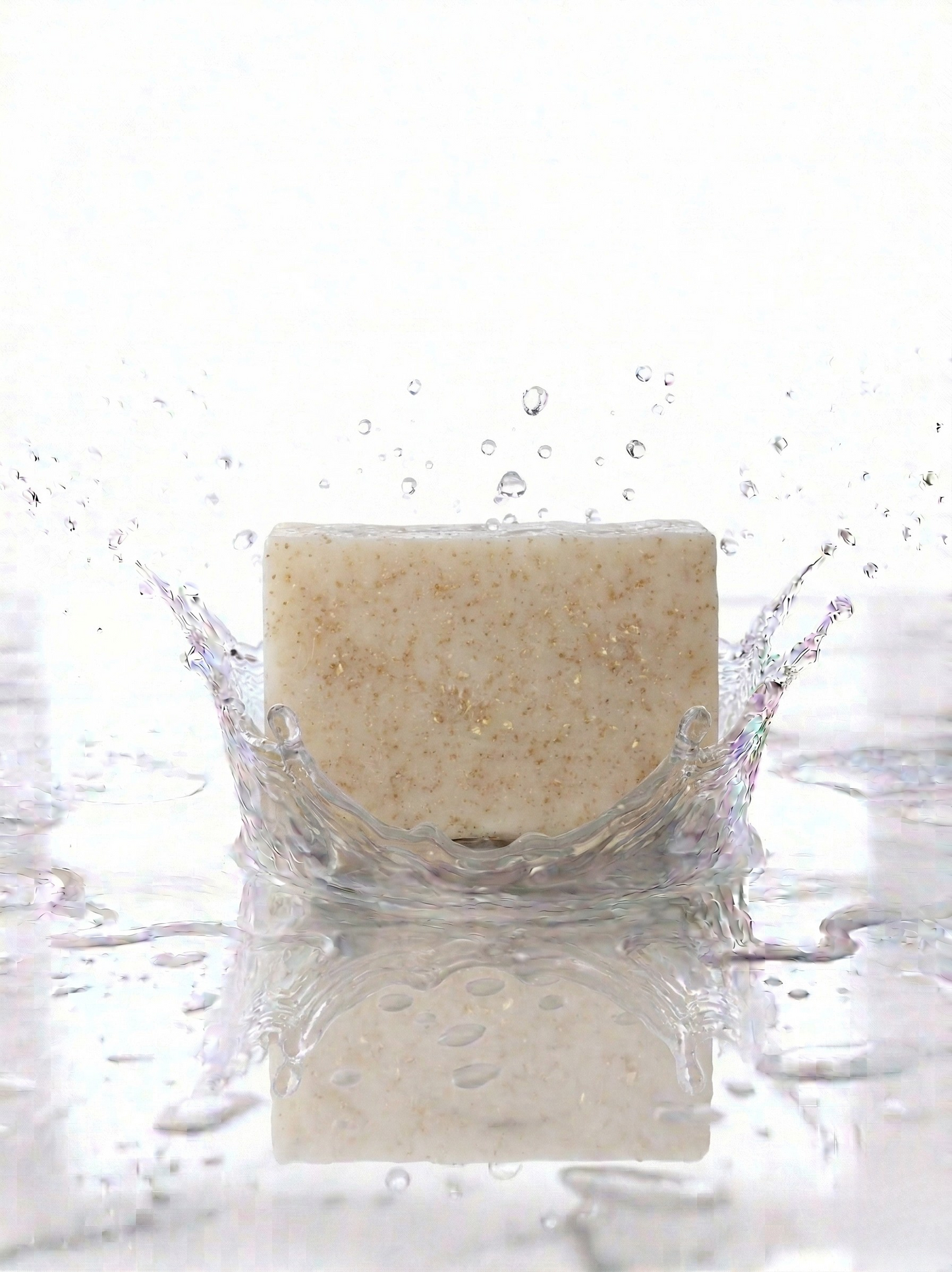 Bar of soap with water droplets and splashes on a white background