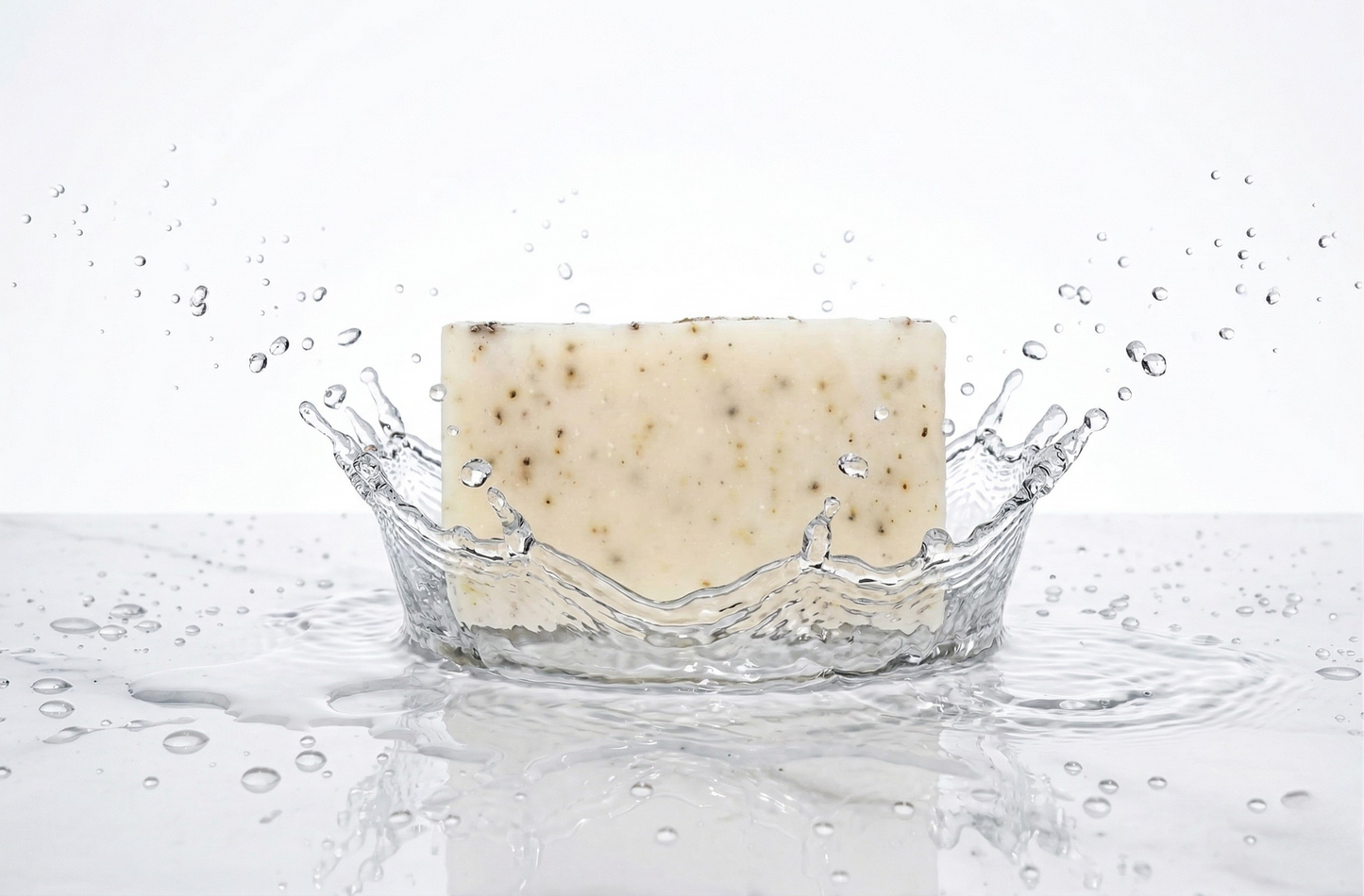 Bar of soap with water droplets and splashes on a white background